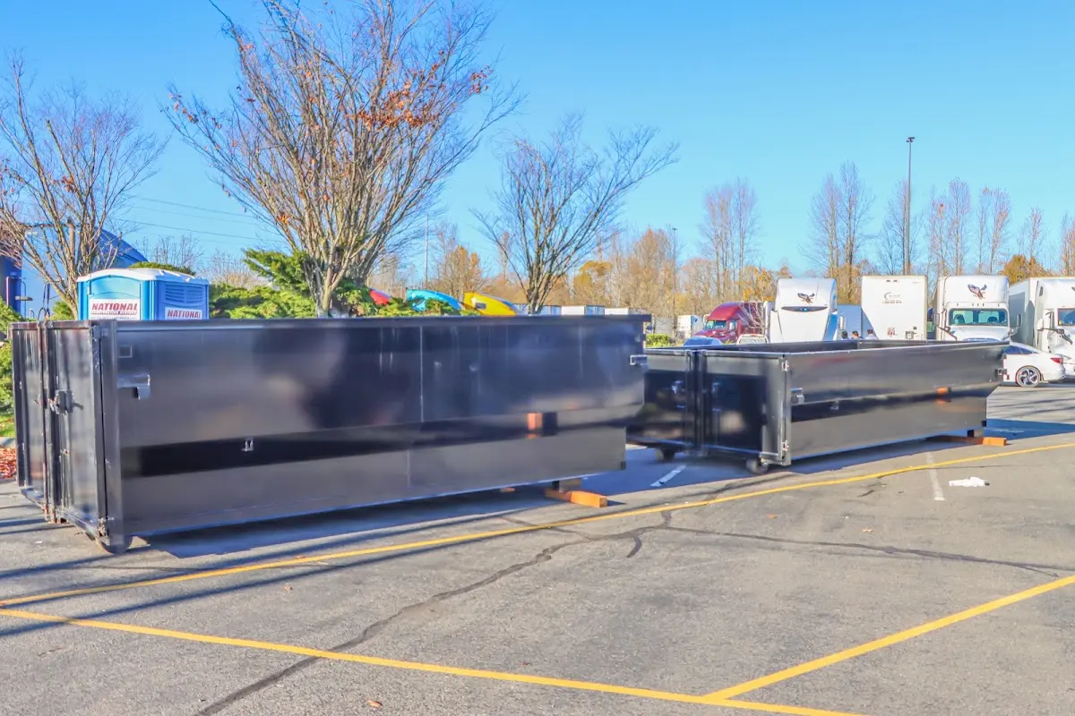 Professional dumpster rental service with roll-off container on residential driveway in West Windsor